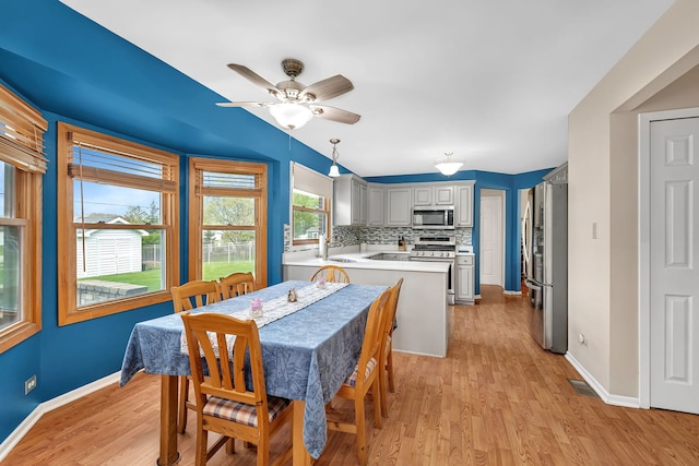 dining room with baseboards, ceiling fan, light wood-type flooring, and visible vents