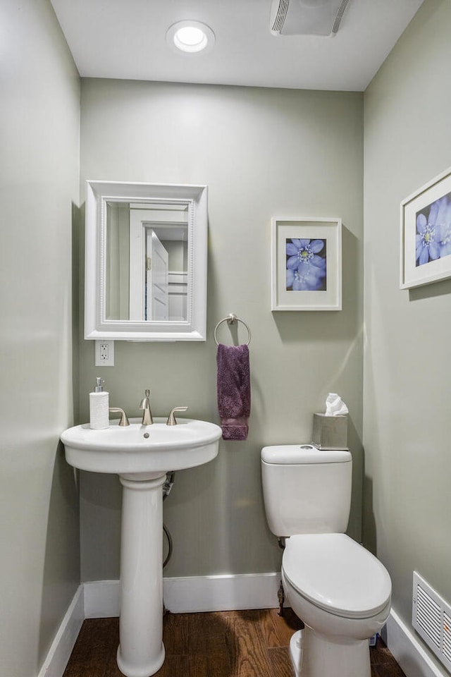 bathroom featuring baseboards, toilet, and wood finished floors