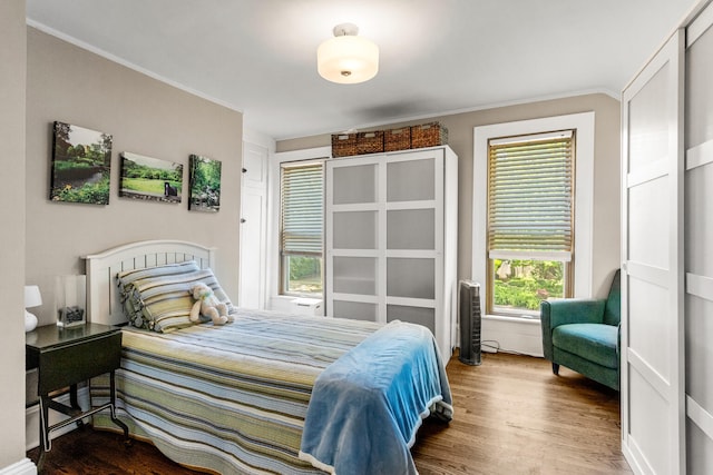 bedroom featuring wood finished floors and ornamental molding