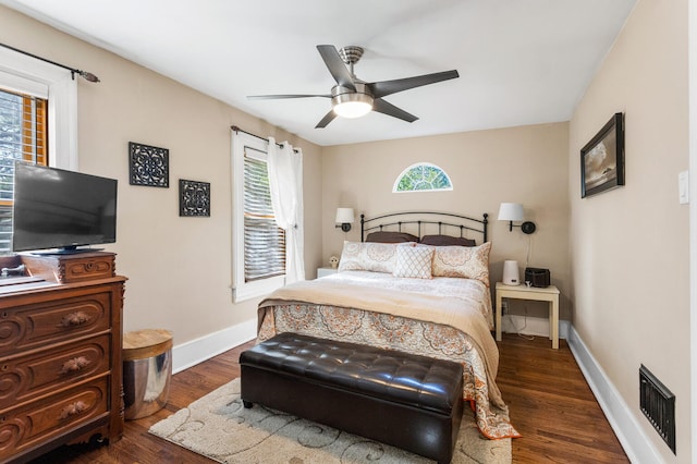 bedroom featuring baseboards, dark wood finished floors, and a ceiling fan