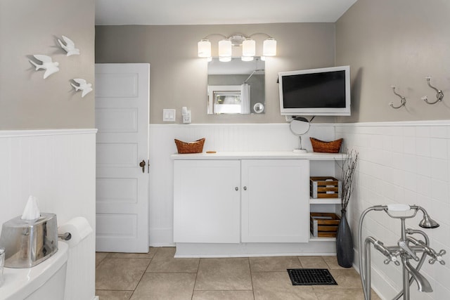 bathroom with a wainscoted wall, tile patterned floors, and vanity