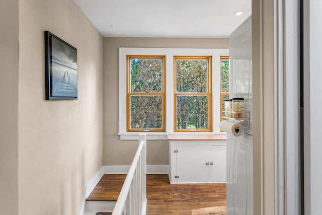 hallway with wood finished floors, baseboards, and recessed lighting
