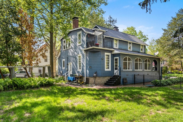 back of property with a chimney, a balcony, and entry steps