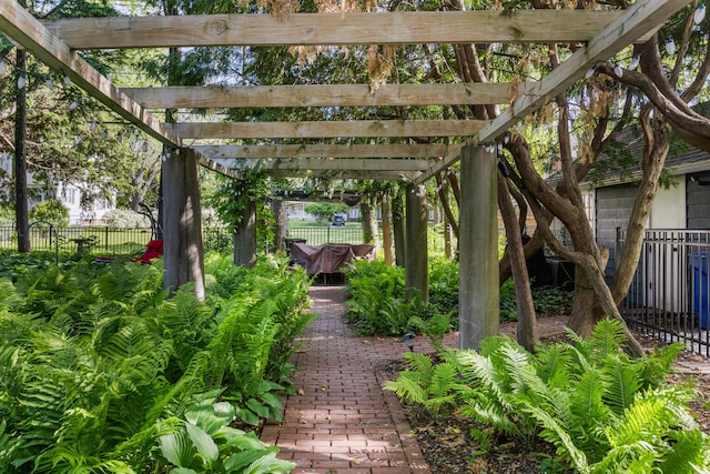 view of property's community featuring fence and a pergola
