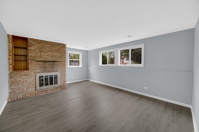 9 Shilling Ct, Bolingbrook, IL 60440 - unfurnished living room featuring a brick fireplace, built in features, baseboards, dark wood-type flooring, and visible vents
