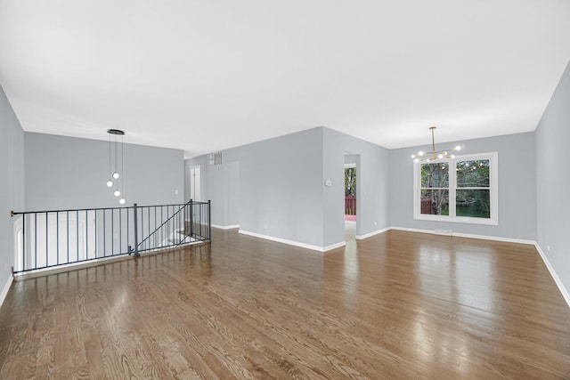 9 Shilling Ct, Bolingbrook, IL 60440 - unfurnished living room featuring an inviting chandelier, baseboards, dark wood-style floors, and visible vents