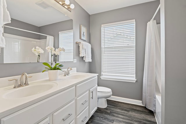 27025 Ashgate Xing, Plainfield, IL 60585 - full bath featuring toilet, wood finished floors, baseboards, double vanity, and shower / tub combo with curtain