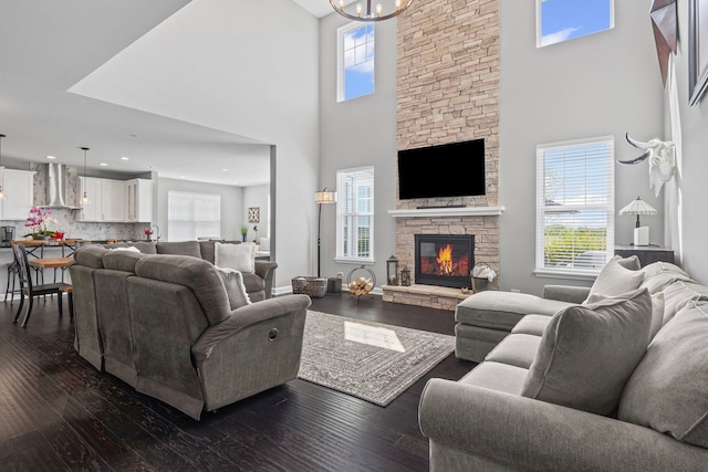 27025 Ashgate Xing, Plainfield, IL 60585 - living room with a high ceiling, plenty of natural light, dark wood-style floors, a chandelier, and a stone fireplace