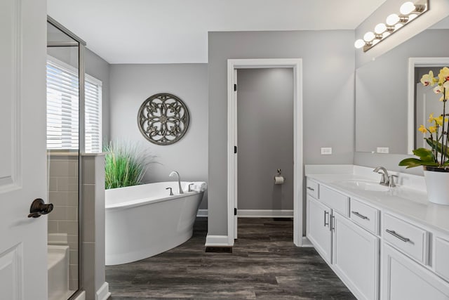 27025 Ashgate Xing, Plainfield, IL 60585 - bathroom featuring a soaking tub, vanity, wood finished floors, and baseboards