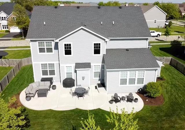 27025 Ashgate Xing, Plainfield, IL 60585 - rear view of house with a patio area and a shingled roof