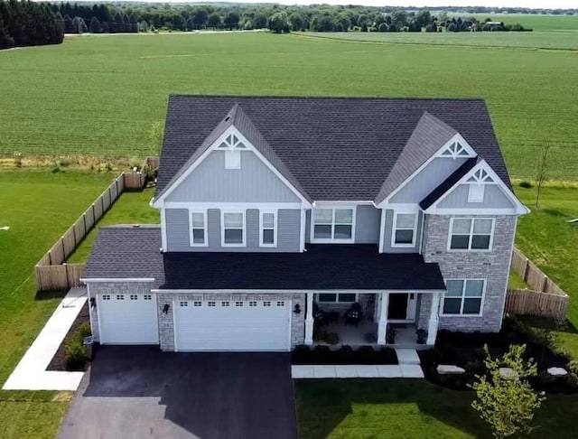 27025 Ashgate Xing, Plainfield, IL 60585 - view of front of property with stone siding, asphalt driveway, a view of rural / pastoral area, a porch, and board and batten siding