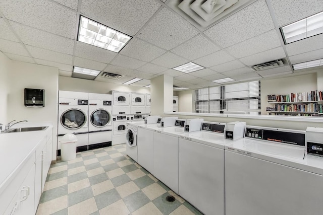 community laundry room with washer and dryer, light floors, visible vents, and a sink