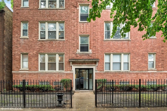 3903 N Claremont Ave Unit 1, Chicago, IL 60618 - view of front facade featuring brick siding and a fenced front yard