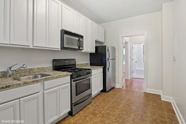 3903 N Claremont Ave Unit 1, Chicago, IL 60618 - kitchen with appliances with stainless steel finishes, a sink, white cabinets, and light stone countertops