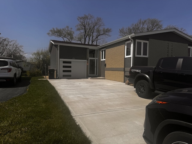 view of home's exterior featuring concrete driveway, brick siding, and an attached garage