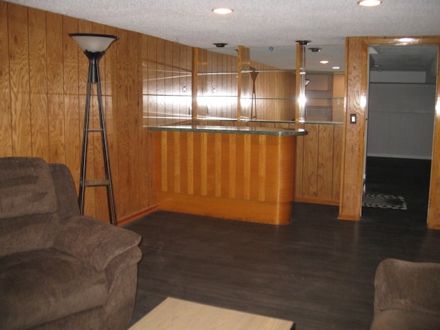 interior space with wooden walls, dark wood finished floors, and a textured ceiling
