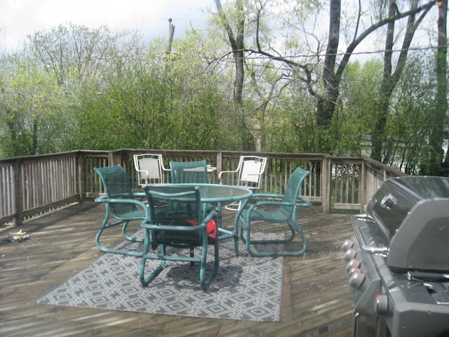 wooden deck featuring a grill and outdoor dining area