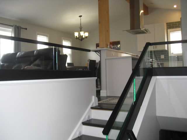 stairway featuring an inviting chandelier and lofted ceiling