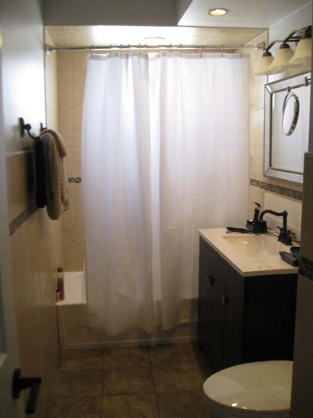 bathroom featuring vanity, shower / tub combo with curtain, and toilet