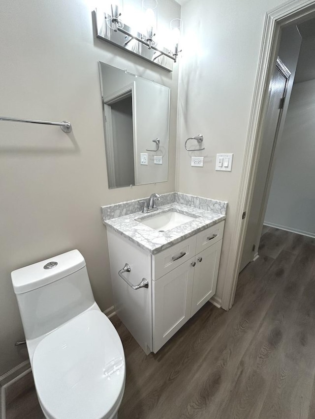 bathroom featuring toilet, wood finished floors, and vanity