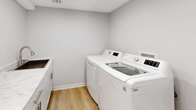 353 Marian Ct, Bolingbrook, IL 60440 - laundry room with washing machine and clothes dryer, cabinet space, light wood-type flooring, and baseboards