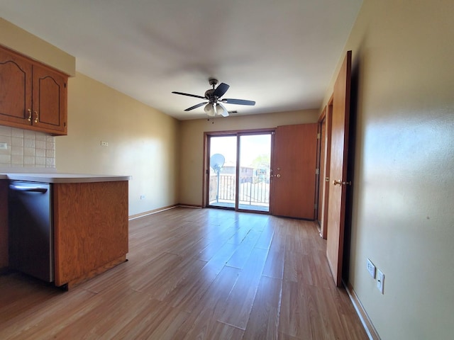 interior space featuring light wood-type flooring, a ceiling fan, and baseboards