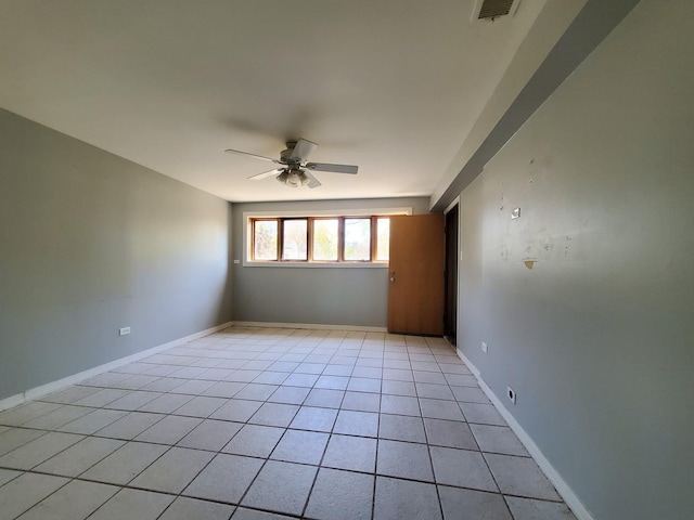 unfurnished room featuring baseboards, ceiling fan, visible vents, and light tile patterned floors
