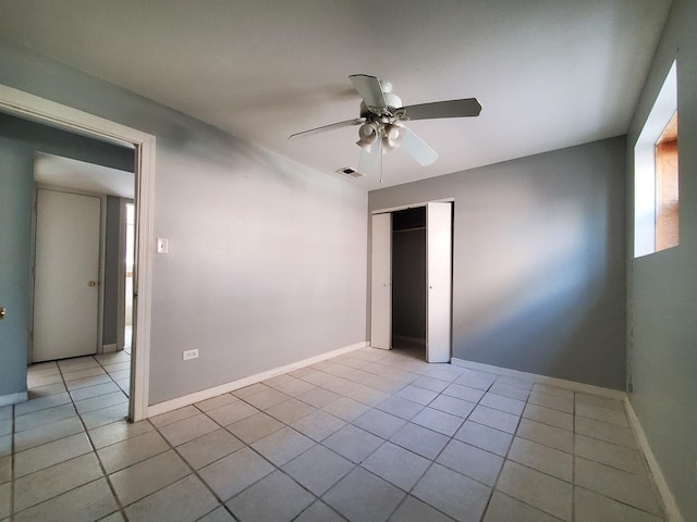 unfurnished bedroom with visible vents, ceiling fan, tile patterned floors, and a closet