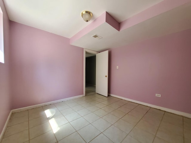 spare room featuring baseboards, light tile patterned flooring, and visible vents