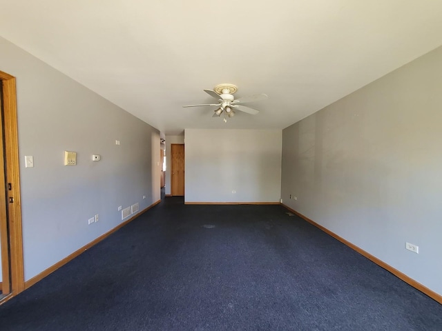 spare room featuring ceiling fan, visible vents, and baseboards