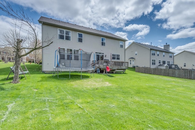 rear view of house with a trampoline and a deck