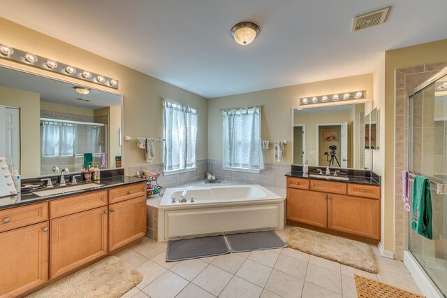 bathroom featuring a shower stall, tile patterned floors, two vanities, and a bath