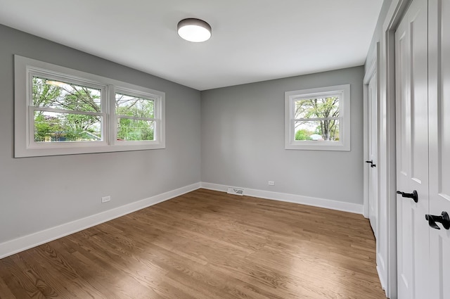 6340 Willow Springs Rd, La Grange Highlands, IL 60525 - unfurnished bedroom featuring multiple windows, baseboards, and light wood-style floors