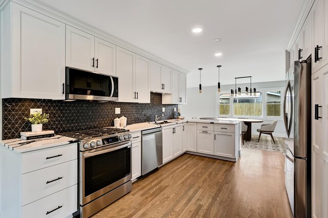 6340 Willow Springs Rd, La Grange Highlands, IL 60525 - kitchen with appliances with stainless steel finishes, a peninsula, light wood-style floors, white cabinetry, and backsplash