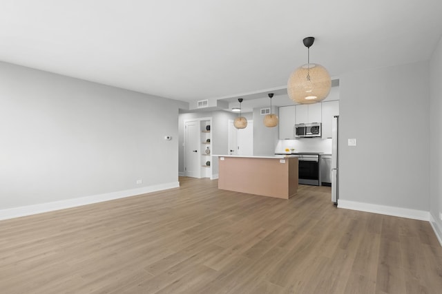 6301 N Sheridan Rd Unit 12C, Chicago, IL 60660 - kitchen featuring stainless steel appliances, a center island, light countertops, open floor plan, and baseboards