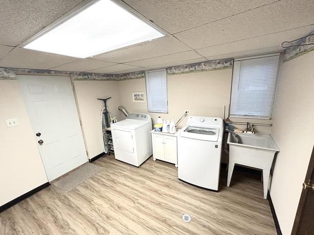 washroom with cabinet space, independent washer and dryer, light wood-style flooring, and baseboards