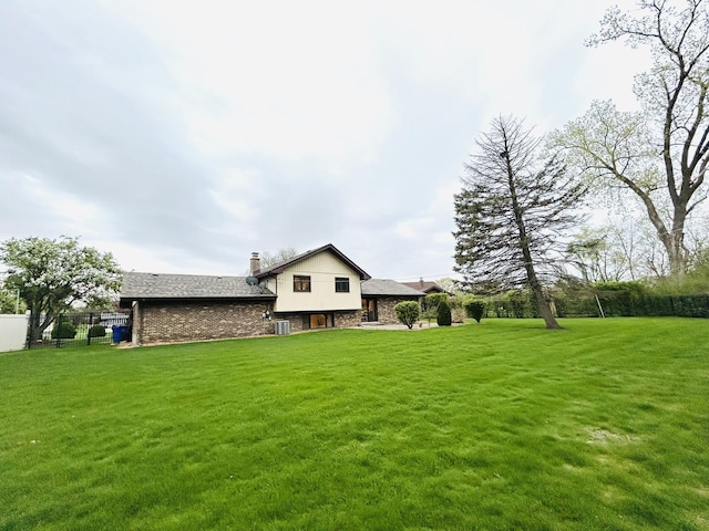 view of front facade featuring a chimney, a front lawn, and fence