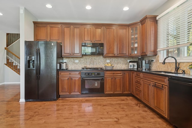 15 Red Tail Dr, Hawthorn Woods, IL 60047 - kitchen with black appliances, a sink, dark countertops, brown cabinetry, and tasteful backsplash