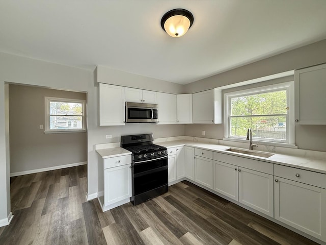 kitchen featuring a sink, light countertops, stainless steel microwave, and double oven range