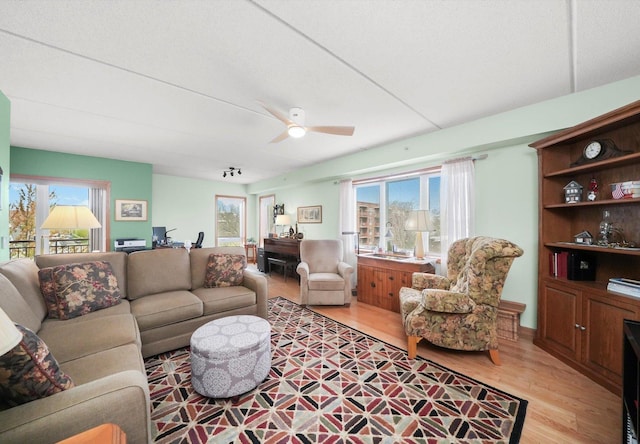 living room featuring light wood-type flooring and a ceiling fan