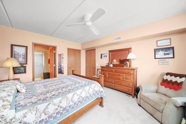 bedroom featuring visible vents, a ceiling fan, and light carpet