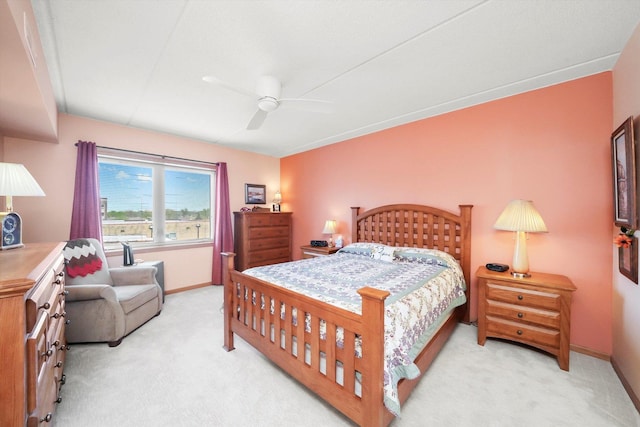 bedroom with light colored carpet, a ceiling fan, and baseboards