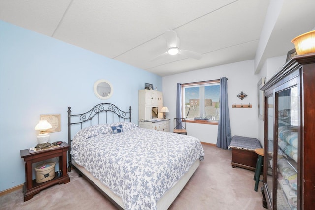 bedroom featuring baseboards, ceiling fan, and light carpet