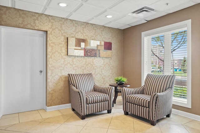 sitting room with baseboards, visible vents, and wallpapered walls