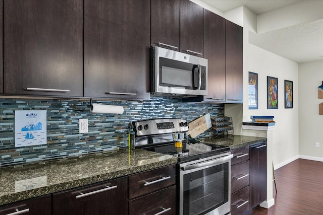 kitchen with appliances with stainless steel finishes, dark wood finished floors, baseboards, backsplash, and dark brown cabinets