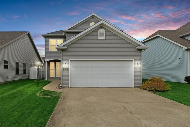 traditional home featuring a lawn, concrete driveway, and a garage