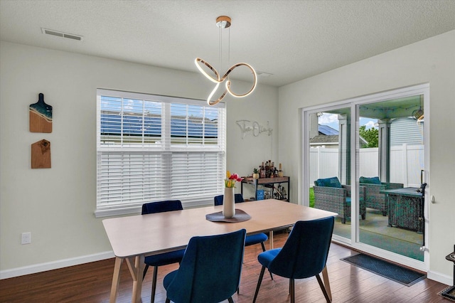 dining room featuring wood finished floors, a textured ceiling, and baseboards