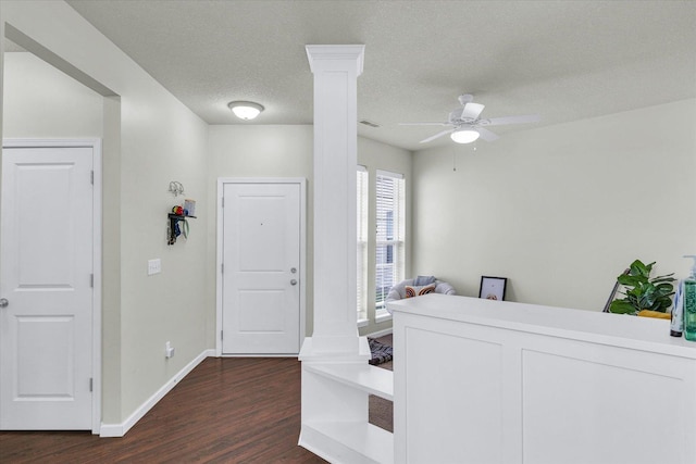 entrance foyer featuring dark wood-type flooring, a ceiling fan, baseboards, and a textured ceiling