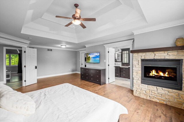 1759 Baybrook Ln, Naperville, IL 60564 - bedroom featuring a raised ceiling, wood finished floors, a stone fireplace, connected bathroom, and baseboards