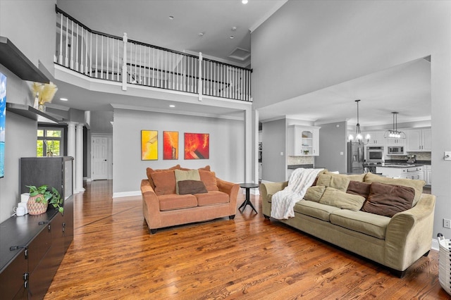 1759 Baybrook Ln, Naperville, IL 60564 - living room featuring wood finished floors, a chandelier, a towering ceiling, baseboards, and ornamental molding